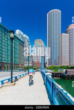 Boston, MA - June 2016, USA: Man cycling on bridge towards Boston downtown in sunny summer day Stock Photo