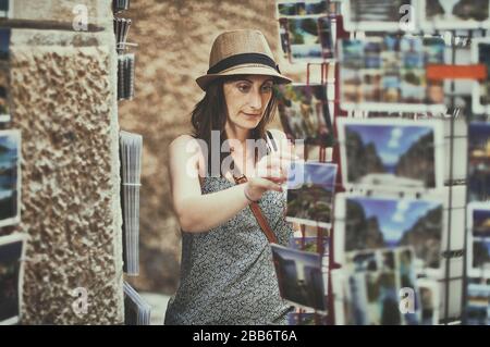 Woman choosing a postcard, Majorca, Balearics, Spain Stock Photo
