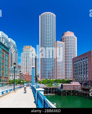 Boston, MA - June 2016, USA: Man cycling on Evelyn Moakley Bridge towards Boston downtown in sunny summer day Stock Photo