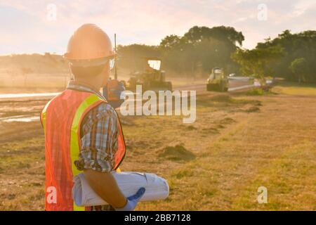 Construction worker on a construction site talking on a walkie talkie, Thailand Stock Photo