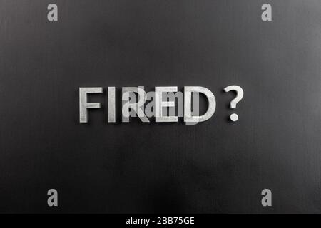 the question fired laid with white brushed metal letters on flat black surface in directly above perspective Stock Photo