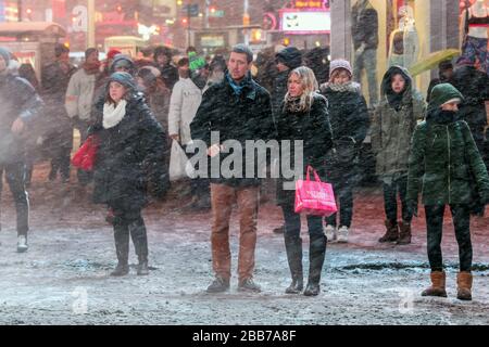 People standing at red light during snow blizzard in Times Square, New York City, USA Stock Photo