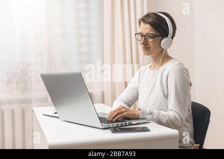 A female freelancer is studying online chatting, talking while sitting at home. Videoconference. Stock Photo
