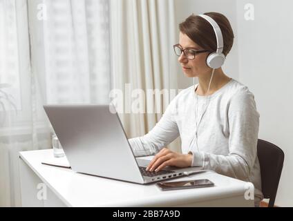 A female freelancer is studying online chatting, talking while sitting at home. Videoconference. Stock Photo