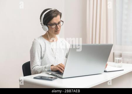 A female freelancer is studying online chatting, talking while sitting at home. Videoconference. Stock Photo