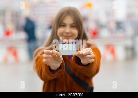 Young woman holds credit bank card in hands Stock Photo