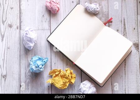 top view of crumpled paper ball and notepad on white background  Stock Photo