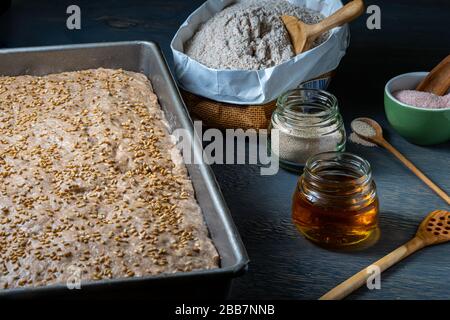 Bread proofing in baking pan with raw ingredients. Stock Photo