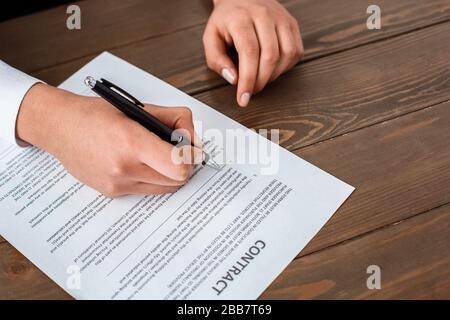 Tour agent sitting at table in office signing contract close-up Stock Photo