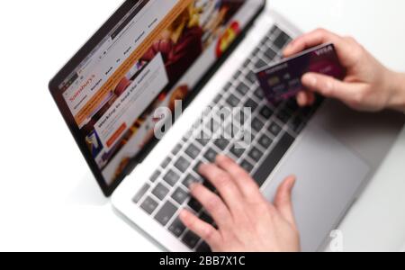 The customer on the Sainsbury's website is pictured holding a bank card as Supermarket websites are overwhelmed by online orders during the COVID-19 Coronavirus pandemic as the UK continues in lockdown to help curb the spread of the coronavirus. Stock Photo