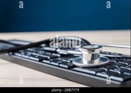 Stethoscope placed on black computer keyboard. Conceptual image of online medicine or it support. Stock Photo