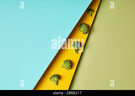 Decor Concept. Broccoli isolated on yellow green and blue background copy space Stock Photo