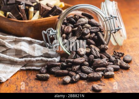 Cocoa beans in jar on wooden table. Cacao fruit on wooden background. Stock Photo
