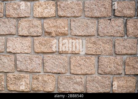 Stone wall texture: brown, orange, terracotta. Stone blocks.  Brown brick wall seamless background. Stock Photo