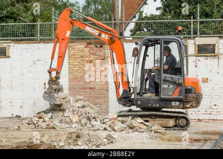 BUCKINGHAM, UK - September 13, 2016. Builder operating a digger to clear rubble during a demolition on a building site in Buckinghamshire, UK Stock Photo