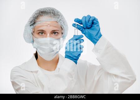 female doctor in protective wear and mask holding medicine for coronavirus Stock Photo