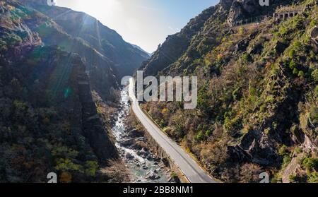 The mountain river along the Road, Aerial panoramic drone view of a scenic highway by the beautiful Landscape covered in clouds and fog, bridge and Stock Photo