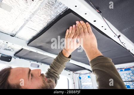Man insulating the roof of his camper van Stock Photo