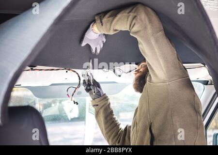 Man installing insulation inside his camper van Stock Photo