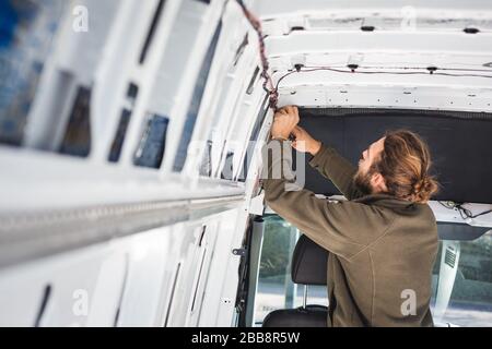 Young man working on his DIY camper van Stock Photo