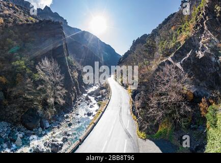 The mountain river along the Road, Aerial panoramic drone view of a scenic highway by the beautiful Landscape covered in clouds and fog, bridge and Stock Photo