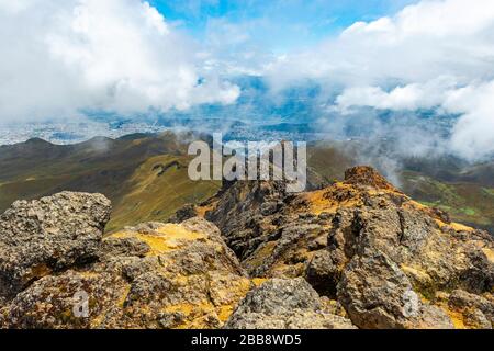 The peaks of the Rucu Pichincha volcano in the Andes mountains with the aerial view over Quito city 2000m lower, Ecuador. Stock Photo