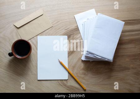 A sheet of paper, envelope, cup of coffee on wooden texture Stock Photo