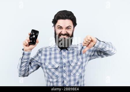 sad hipster man with broken smartphone screen shows dislike, concept of searching for a gsm service for repair a device Stock Photo
