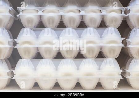 Chicken eggs in a plastic box packing on a shelf in a supermarket store. Stock Photo
