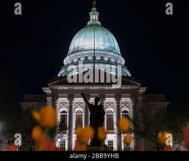 MADISON, WISCONSIN - MAY 07, 2018: Low angle view, behind the capitol grounds tulip garden, of the State Capitol building and the replica statue Stock Photo