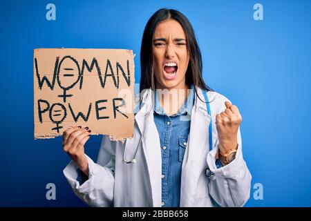 Young doctor woman wearing stethoscope holding cardboard banner with powe message annoyed and frustrated shouting with anger, crazy and yelling with r Stock Photo