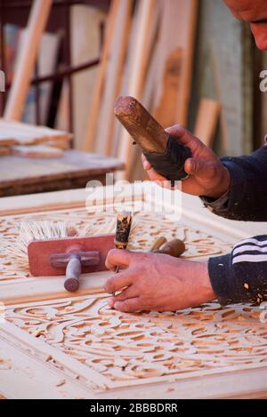Close-up of the hands of a woodworker in the streets of Marrakesh, manually sculpting a piece of furniture. Stock Photo