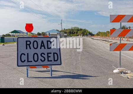 Road closed sign, with barricades and traffic cones, posted at Citrus County Florida's Fort Island Gulf Beach, indicate beach closure due to COVID-19. Stock Photo