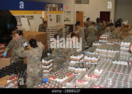 Soldiers of the California Army National Guard’s 115th Regional Support Group form an assembly line and diligently pack food March 21 at the Sacramento Food Bank & Family Service in Sacramento, California. California Guardsmen were activated to assist the state during the recent COVID-19 outbreak. (Army National Guard photo by Staff Sgt. Eddie Siguenza) Stock Photo