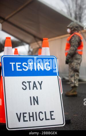 A New Jersey National Guard Airman provides traffic control at a COVID-19 Community-Based Testing Site at the PNC Bank Arts Center in Holmdel, N.J., March 23, 2020.  The testing site, established in partnership with the Federal Emergency Management Agency, is staffed by the New Jersey Department of Health, the New Jersey State Police, and the New Jersey National Guard. (U.S. Army National Guard photo by Spc. Michael Schwenk) Stock Photo