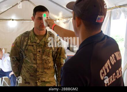 Florida National Guard Soldiers with the 50th Regional Support Group get screened daily as they work to support Community Based Test Sites, March 24, 2020. During the screening, temperatures are check and series of questions are examined to identify symptoms. Stock Photo