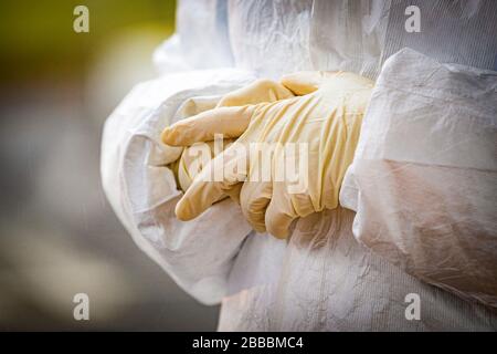 A medical technician adjusts her gloves at a COVID-19 Community-Based Testing Site at the PNC Bank Arts Center in Holmdel, N.J., March 23, 2020.  The testing site, established in partnership with the Federal Emergency Management Agency, is staffed by the New Jersey Department of Health, the New Jersey State Police, and the New Jersey National Guard. (U.S. Air National Guard photo by Master Sgt. Matt Hecht) Stock Photo