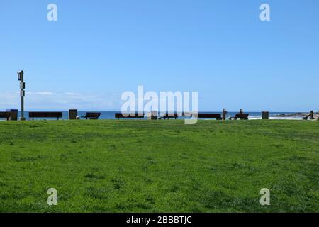 A row of benches overlooking the beautiful Pacific Ocean on a clear day in Laguna Beach Stock Photo