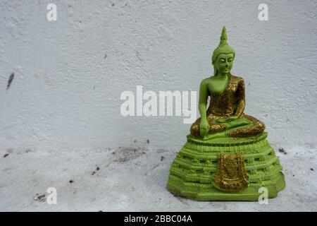 Miniature Emerald Green Buddha Statue against the White Background Stock Photo