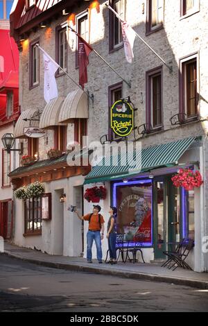 Couple in front of a small, independent grocery store on rue des Jardins in the historic Upper Town of Old Quebec City, Province of Quebec, Canada Stock Photo