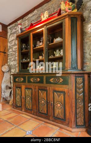 Hand-carved wooden buffet against an old fieldstone wall in the dining room with terracotta ceramic tile flooring inside an old circa 1830 Quebecois style country home, Quebec, Canada. This image is property released. CUPR0357