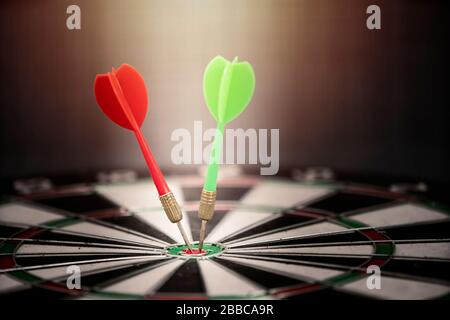 Close up red and green dart arrow hitting on target center of dartboard, business concept