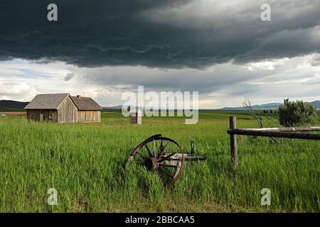 Farm house with storm clouds looming, Chesterfield, Idaho, USA Stock Photo