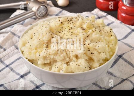 A bowl of garlic mashed potatoes with pepper and melting butter Stock Photo