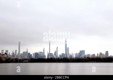 New York City, New York, United States. 30th Mar, 2020. Midtown Manhattan skyline as seen from the north end of Central Park Reservoir on Monday, on March 30th on a cloudy and damp day, and as New York's streets remained nearly empty in response to the coronavirus pandemic and shelter in place guidelines. Credit: Adam Stoltman/Alamy Live News Stock Photo