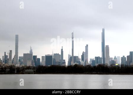 New York City, New York, United States. 30th Mar, 2020. Midtown Manhattan skyline as seen from the north end of Central Park Reservoir on Monday, on March 30th on a cloudy and damp day, and as New York's streets remained nearly empty in response to the coronavirus pandemic and shelter in place guidelines. Credit: Adam Stoltman/Alamy Live News Stock Photo