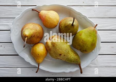 Pears, mixed, varieties, selection, overhead, group, white, bowl, wood ,table, William, Comice, Concorde, Forelle, Conference, sweet, juicy, fruit, st Stock Photo