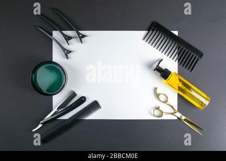 Scissors, hair clipper, combs, dangerous razor, gel for haircuts on a blue sheet on black background. Hairdressing concept Stock Photo