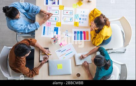 Top view ux developer and ui designer brainstorming about mobile app interface wireframe design on table with customer breif and color code at modern Stock Photo
