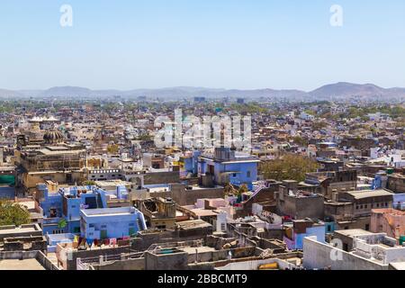 A view over rooftops in central Udaipur during the day. Hills can be seen in the distant. Stock Photo